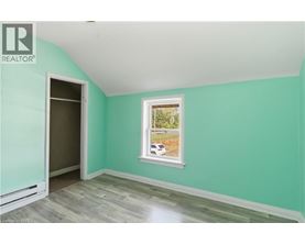 A room with a ceiling fan and a window letting in sunlight.