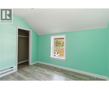 A room with a ceiling fan and a window letting in sunlight.