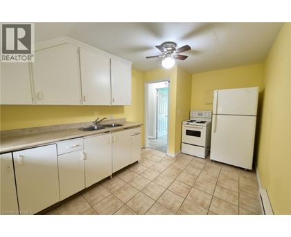 A kitchen with white cabinets and a white fridge.