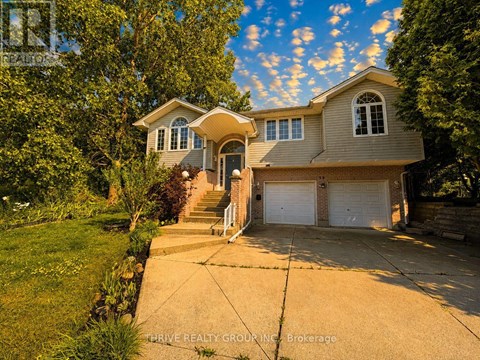 A house with a driveway and garage doors is for sale.
