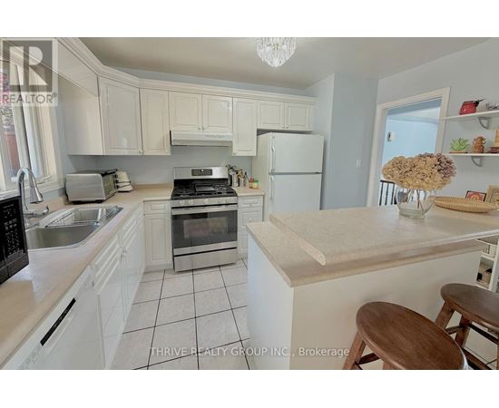 A kitchen with white cabinets and a wooden island.