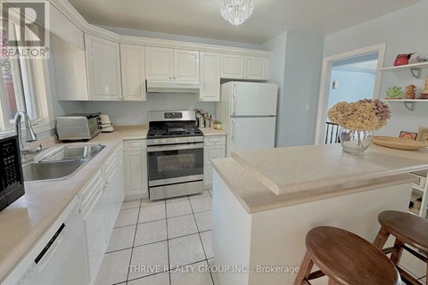 A kitchen with white cabinets and a wooden island.