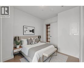 A bedroom with a bed, nightstand, and lamp.