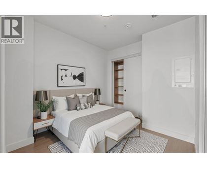 A bedroom with a bed, nightstand, and lamp.