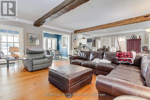 A living room with a brown leather couch and a grey armchair.