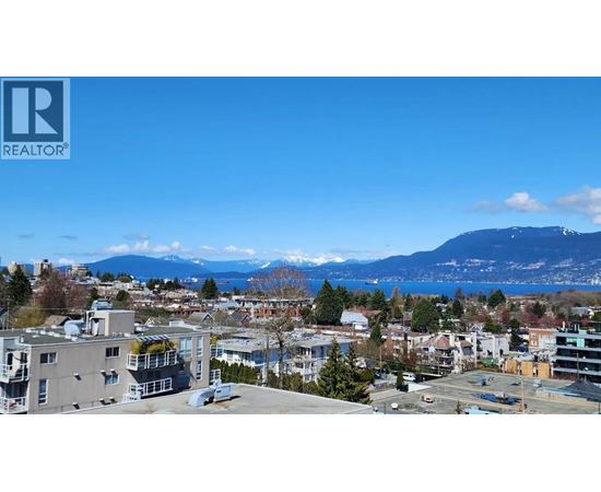 A cityscape with buildings and a mountain in the background.