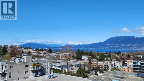 A cityscape with buildings and a mountain in the background.