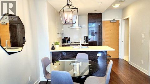A modern kitchen with a dining table and chairs.