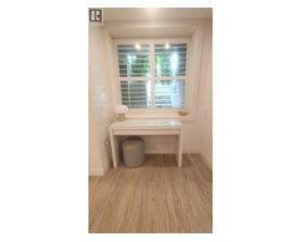 A room with a window and a desk.