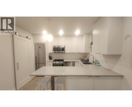 A kitchen with white cabinets and a countertop.