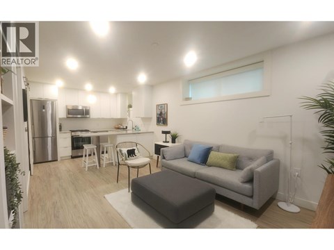 A living room with a grey couch and a white chair.