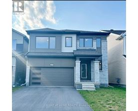 A modern house with a grey garage door is for sale.