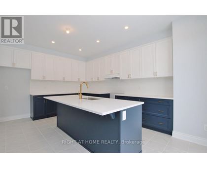 A kitchen with white cabinets and a white island.