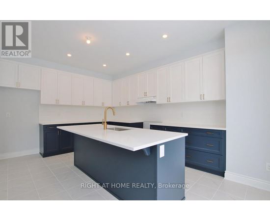 A kitchen with white cabinets and a white island.