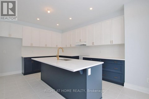 A kitchen with white cabinets and a white island.