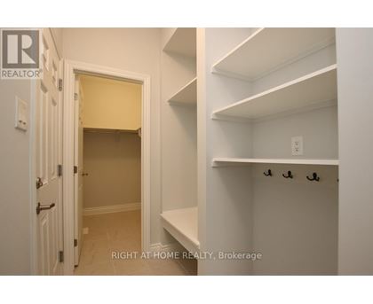 A white hallway with a doorway leading to a bedroom.