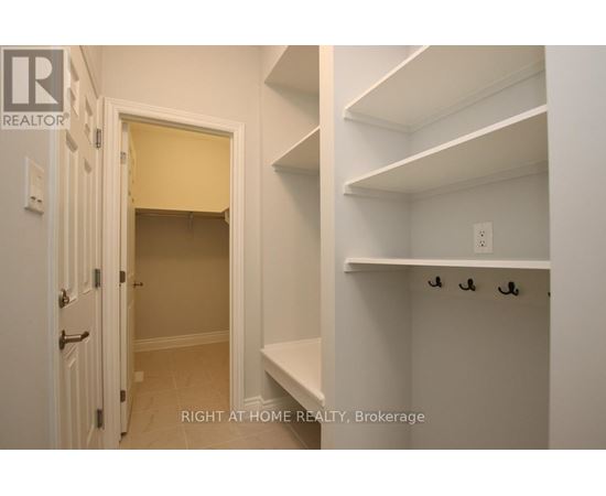 A white hallway with a doorway leading to a bedroom.