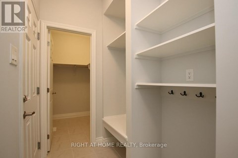 A white hallway with a doorway leading to a bedroom.