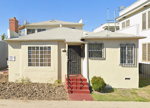 A small house with a red staircase leading to the front door.