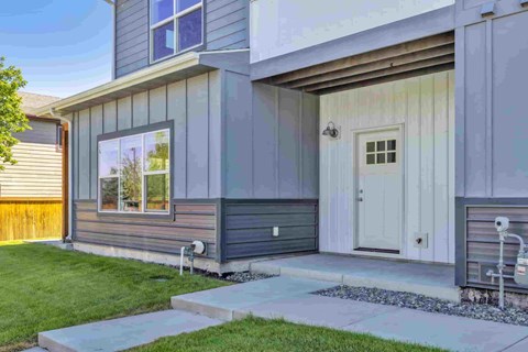 A modern house with a grey exterior and a white door.