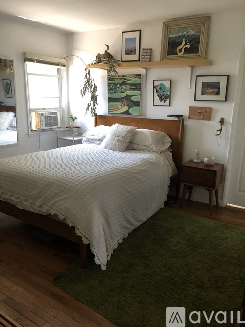 A bedroom with a large bed and a green rug.
