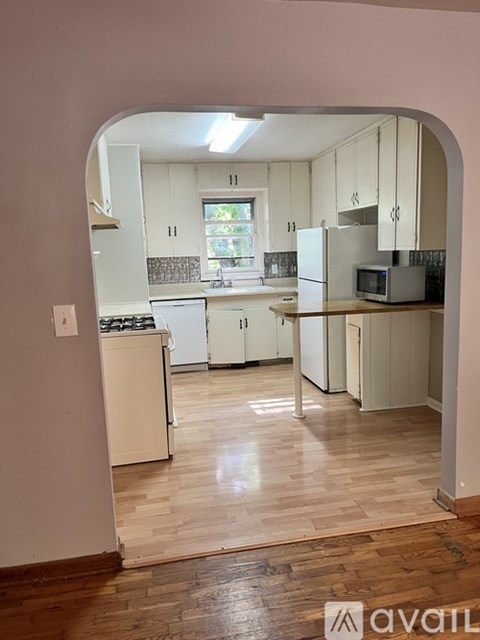 A kitchen with white appliances and cabinets.