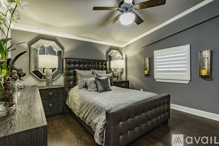 A bedroom with a large bed and a ceiling fan.