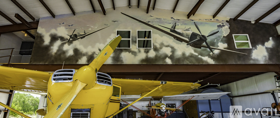 A yellow helicopter is in the foreground of a building with a mural of two helicopters in the background.
