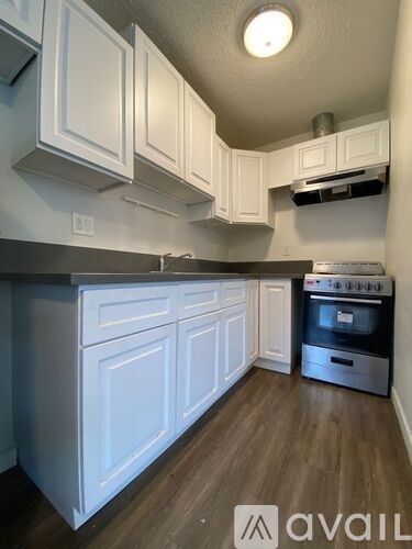 A kitchen with white cabinets and a stainless steel oven.