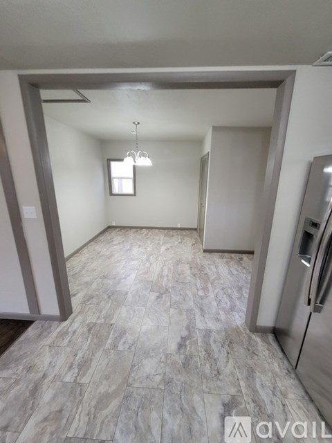 A kitchen with a refrigerator on the right side.
