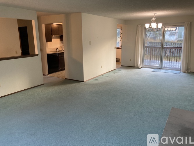 A spacious living room with a sliding glass door leading to a backyard.