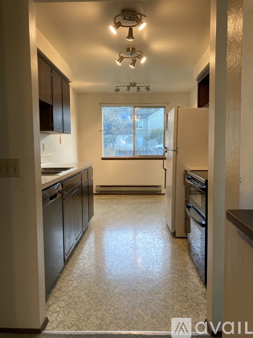 A kitchen with black cabinets and a tiled floor.