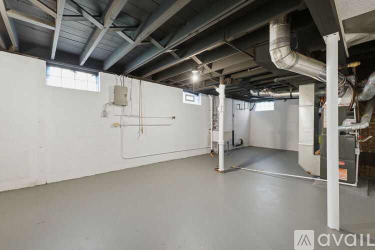 A large empty industrial space with white walls and a concrete floor.