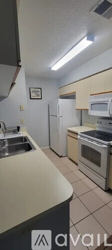 A kitchen with white appliances and a white refrigerator.