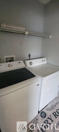 A white washing machine and dryer in a laundry room.
