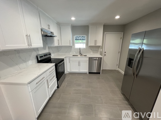 A kitchen with white cabinets and a black oven.