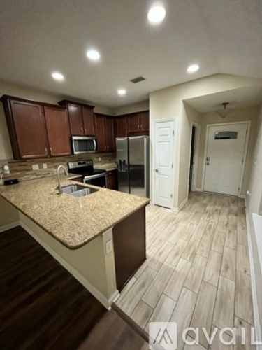 A kitchen with brown cabinets and a granite countertop.