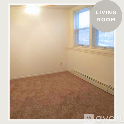 A living room with a window and carpeted floor.
