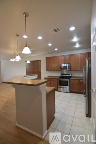A kitchen with wooden cabinets and a white island.