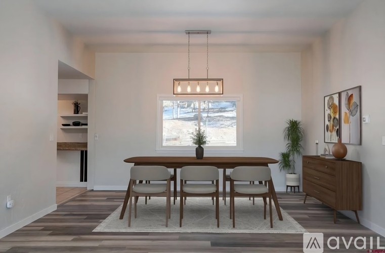 A modern dining room with a wooden table and chairs.