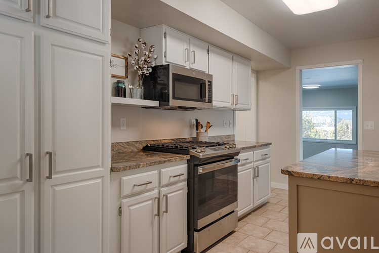 A kitchen with white cabinets and a granite countertop.
