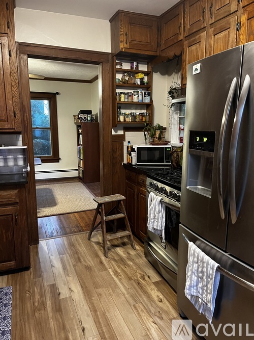 A kitchen with a refrigerator on the right and a microwave on the left.