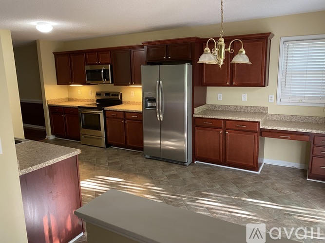 A kitchen with brown cabinets and a stainless steel refrigerator.