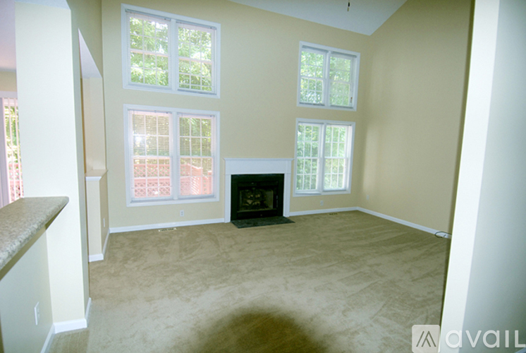 A living room with a fireplace and large windows.
