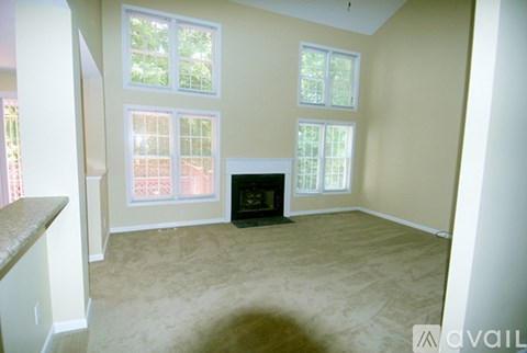 A living room with a fireplace and large windows.