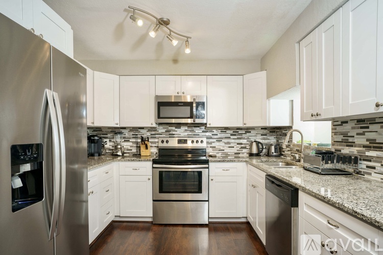 A modern kitchen with stainless steel appliances and white cabinets.