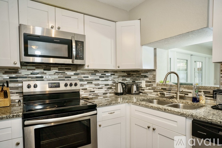 A kitchen with a black stove top oven and a black microwave above it.