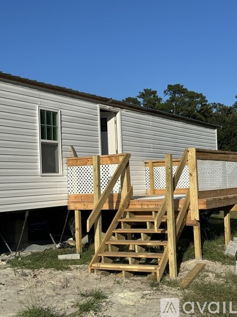 A wooden staircase leads to a door on a house under construction.