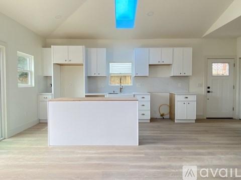 A kitchen with white cabinets and a large island.