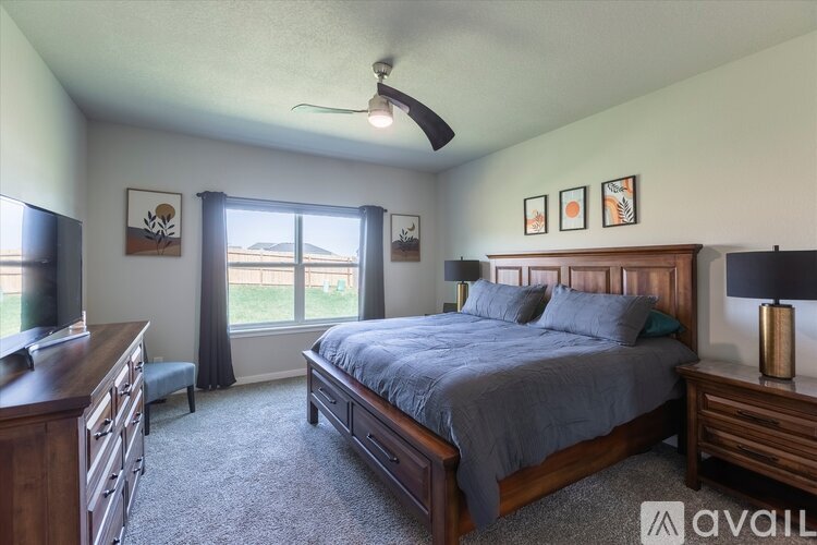 A bedroom with a large bed and a ceiling fan.